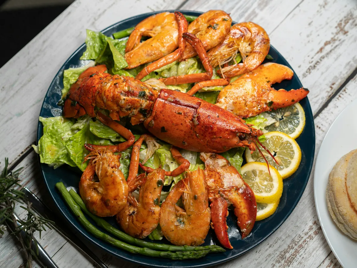 Đĩa tôm hùm và tôm sú nướng với chanh và rau xanh